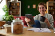 © Stockphotodirectors - Women using digital tablet to check her finances at home office