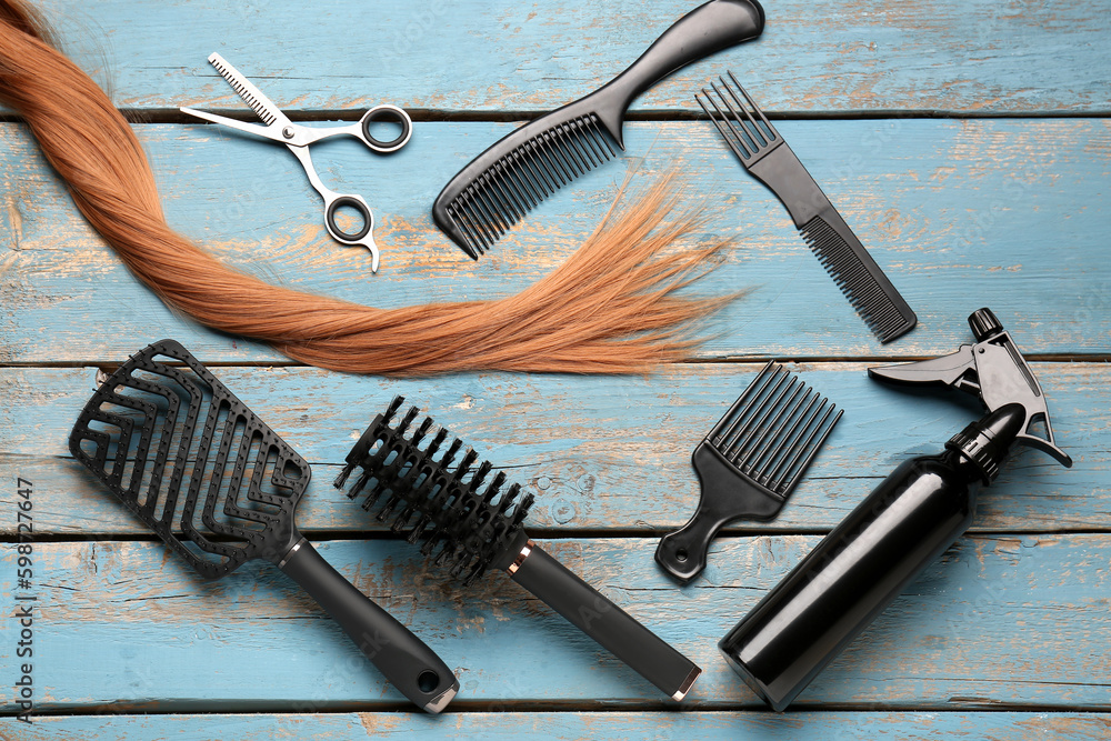 Ginger hair with brushes, scissors and spray on blue wooden background