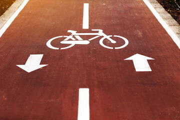 New marking bike path. White bicycle symbol and two oposite arrows on red asphalt lane, road. Bicycle path in the city. Two-way cycle lane on an avenue. Lifestyle. Urban traffic and transportation