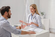 © New Africa - Happy doctor consulting patient at white table in clinic