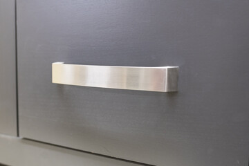 Sticker - front view of closed sliding wooden drawer with metal long handles