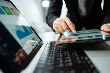 Wall Mural - Close up of view Businesswomen using apps on smartphones and laptop computer to analyze business report graphs and finance charts at the workplace, Business strategy, financial and investment concept.