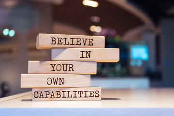 Wooden blocks with words 'Believe in your own capabilities'.