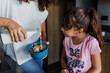 Latin single mother and daughter eating milk and cereal for breakfast at kitchen in Mexico Latin America, hispanic people