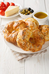 Canvas Print - Acma Turkish Style Soft Bagels served with tomato, cheese, olive and olive oil closeup on the plate on the table. Vertical