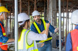 © Akarawut - Team of engineer, architect, contractor and foreman meeting and consulting in construction building site for inspection in real estate development project industry and specification quality control