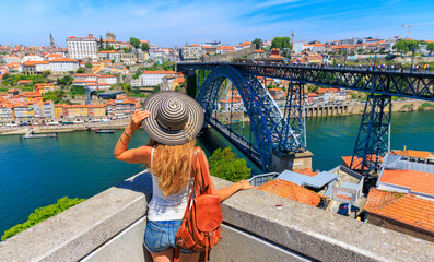 Wall Mural - woman tourist enjoying beautiful panoramic view of douro river, old town and famous iron bridge- tou