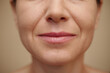 © DragonImages - Lower face part of smiling mature woman
