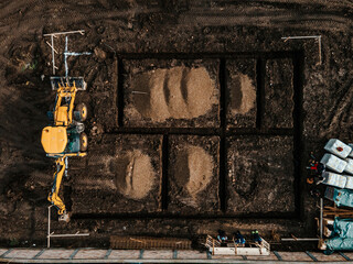 Wall Mural - Aerial view of an earth digger digging foundation on a reconstruction site.