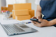 © Witoon - Asian Male SME Small Business Entrepreneur Working Freelance From Home Use smartphones and laptops for commercial inspections. online marketing Packaging Box SME Seller Concept Ecommerce Team online s
