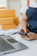 © Witoon - Asian Male SME Small Business Entrepreneur Working Freelance From Home Use smartphones and laptops for commercial inspections. online marketing Packaging Box SME Seller Concept Ecommerce Team online s