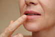 © DragonImages - Middle-aged woman applying hydrating treatment on lips
