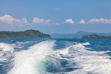 Wall Mural - Waves from a speedboat on the blue sea with splashes and a trail from a boat or yacht. The concept of travel and voyage while on vacation in hot Asian countries.