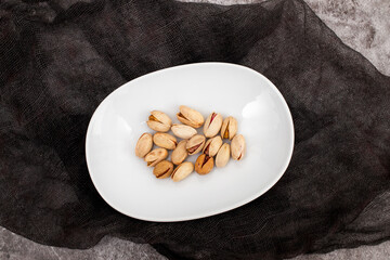 Poster - fresh salted pistachio on white small dish