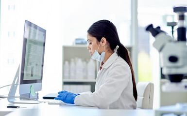 Canvas Print - Doing some more research online. a young scientist working on a computer in a lab.