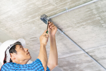 Wall Mural - construction worker and contractor. Electrician prepare to wire electric system on the ceiling in reconstruction room.