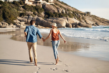 Wall Mural - Happiness is a walk on the beach. a middle aged couple spending the day at the beach.