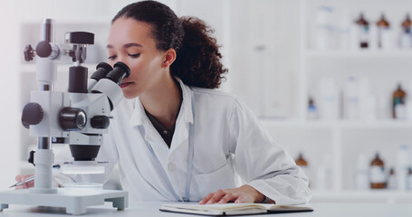 Wall Mural - another day of making new discoveries. a young scientist using a microscope in a lab.