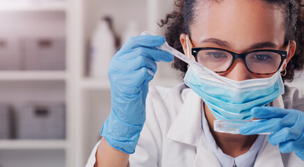 Wall Mural - lets test this. a young scientist analysing samples in a lab.
