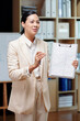 © DragonImages - Positive entrepreneur showing report and explaining results of work to colleagues