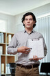 © DragonImages - Serious businessman pointing at chart in hands when speaking in meeting