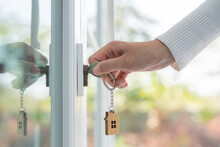 Landlord Key For Unlocking House Is Plugged Into The Door. Second Hand House For Rent And Sale. Keychain Is Blowing In The Wind. Mortgage For New Home, Buy, Sell, Renovate, Investment, Owner, Estate