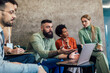 © Mediteraneo - Businesspeople working in an office lobby. Group of  businesspeople sitting together in a co-working space