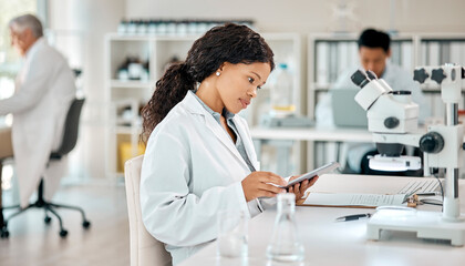 Wall Mural - i will figure this all out. a young scientist using a digital tablet in a lab.