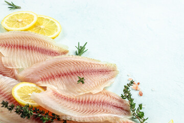 Sticker - healthy tilapia fish fillets with lemon on a light background. banner, menu, recipe place for text, top view