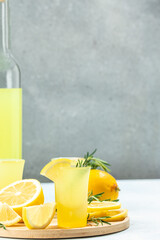 italian lemon alcohol drink limoncello with lemon and rosemary. vertical image. top view. place for text