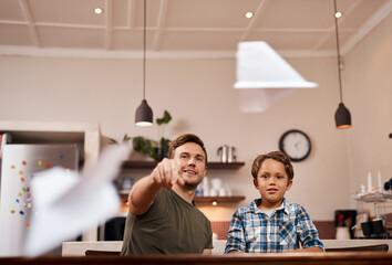 Wall Mural - Looks like Im going down. a man and his young son playing with paper planes at home.