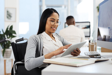 Wall Mural - Comparing notes. an attractive young businesswoman working on a tablet at her desk in the office.