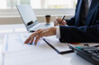 © Witoon - Asian businessman working at office with laptop, tablet and graph data sheet on his desk.