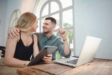 Wall Mural - Girl and young man with casual lifestyle working on laptop computer in her studio. Two Caucasian Couples Sitting Outside Workplace