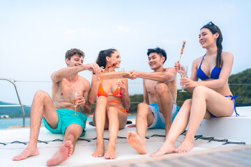 happy man in swimwear and woman in bikini having laugh fun in summer trip with friends group by eat bar-b-q grill and wine party drink, friendship vacation travel on sailboat yacht at the ocean sea