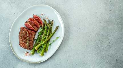 Wall Mural - sliced beef grill steak with green asparagus. Healthy dinner or lunch. Long banner format. top view