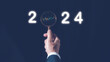 © cherdchai - 2024 business planning and strategy concept, businessman holding magnifying glass with the year 2024, marketing financial and research analysis, investment trends next new year