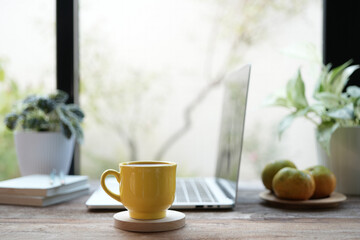 Wall Mural - yellow coffee cup and laptop and white flowers on white table indoor work from home