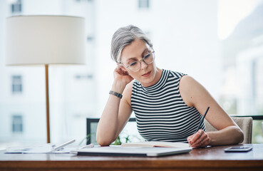 Wall Mural - Stay dedicated and organized. of a mature businesswoman writing in her notebook.