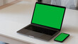 © DomenicoFornas - A Green Screen Laptop and a Smartphone on a White Table