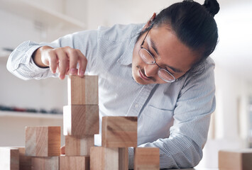 Sticker - Innovation is the catalyst for change. a young businessman working with wooden building blocks in a modern office.