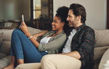 Poster - Theres an app for everything nowadays. a happy young couple using a digital tablet together while relaxing on a couch at home.