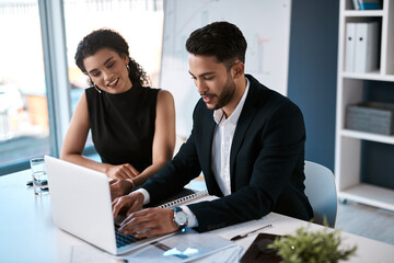 Wall Mural - We both can work, but together we will win. two young business colleagues sitting together and using a laptop in the office.