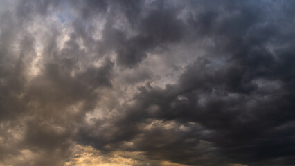 Wall Mural - stormy dramatic sky with dense rain clouds and backlight