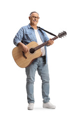 Wall Mural - Full length portrait of a mature man standing and playing an acoustic guitar