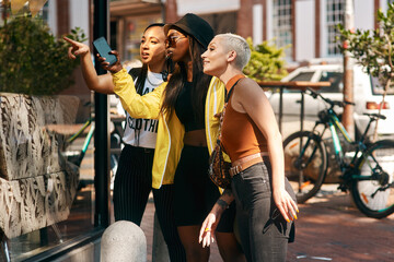 Aufkleber - Getting our daily dose of window shopping. three close friends spending the day together in the city.