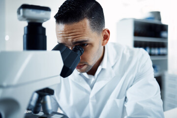 Wall Mural - so close i can see everything. a young scientist using a microscope in a laboratory.