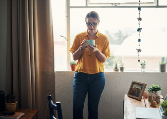 Canvas Print - Coffee replenishes my soul. an attractive young businesswoman standing in her home office and holding a cup of coffee.