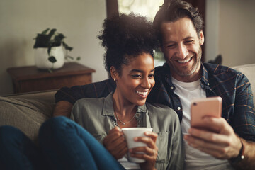 Wall Mural - Look at these messages with me. a happy young couple using a cellphone together while relaxing on a couch at home.