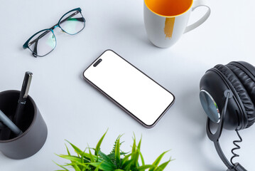 Aufkleber - Phone mockup with isolated screen for app presentation placed on office desk, surrounded by coffee mug, glasses, pens, plant and headset.